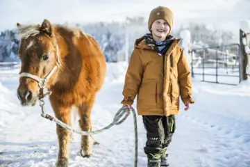 Kind mit Pony beim Familienurlaub im Chiemgau